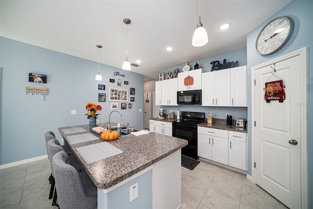 kitchen with black appliances, decorative light fixtures, a center island with sink, and sink