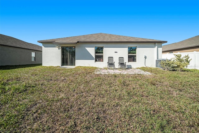 rear view of house featuring a yard