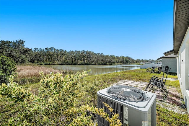 view of yard featuring a patio area, a water view, and central air condition unit