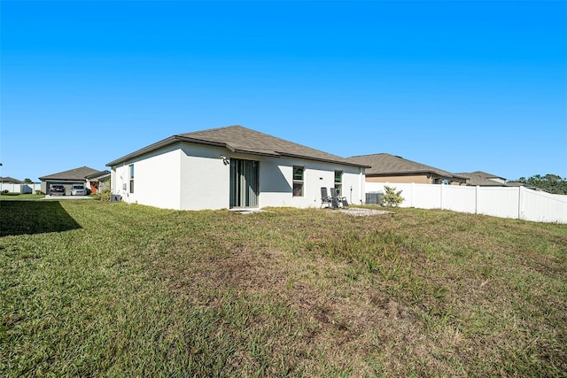 rear view of property featuring a lawn