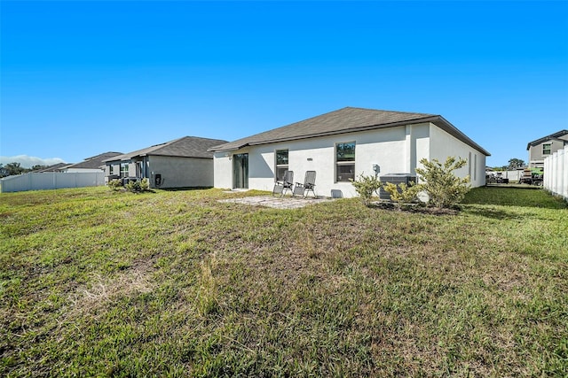 rear view of property featuring a yard and central AC unit