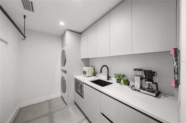 laundry area with sink and stacked washer and clothes dryer