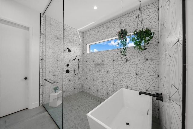 bathroom featuring sink, tile walls, and shower with separate bathtub