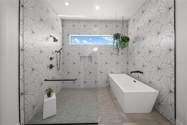 bathroom featuring tile walls, a bathtub, and tile patterned flooring