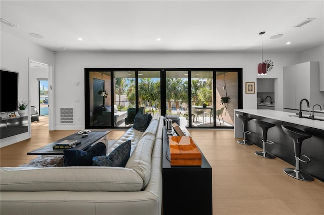 living room with sink and light hardwood / wood-style floors