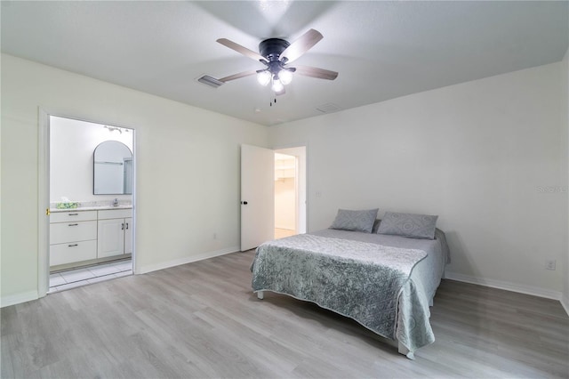 bedroom with ceiling fan, sink, ensuite bathroom, and light wood-type flooring