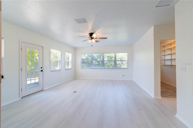 spare room featuring a textured ceiling, light hardwood / wood-style flooring, and ceiling fan