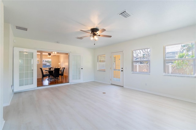 unfurnished room featuring french doors, light wood-type flooring, and ceiling fan