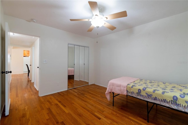 bedroom with hardwood / wood-style floors, ceiling fan, and a closet