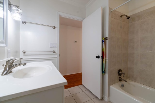 bathroom with tile patterned floors, tiled shower / bath, vanity, and ornamental molding