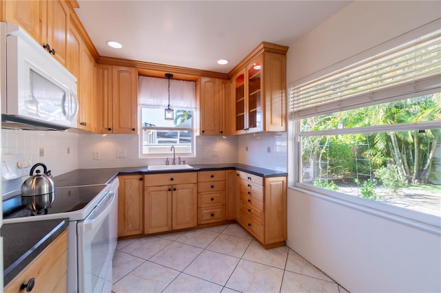 kitchen featuring tasteful backsplash, sink, pendant lighting, and white appliances