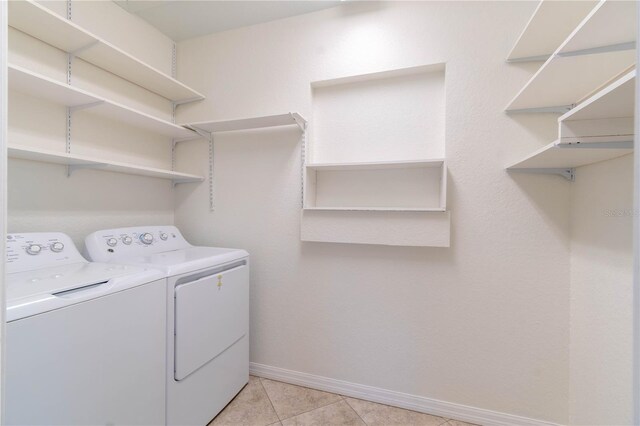 laundry area featuring washing machine and clothes dryer and light tile patterned flooring