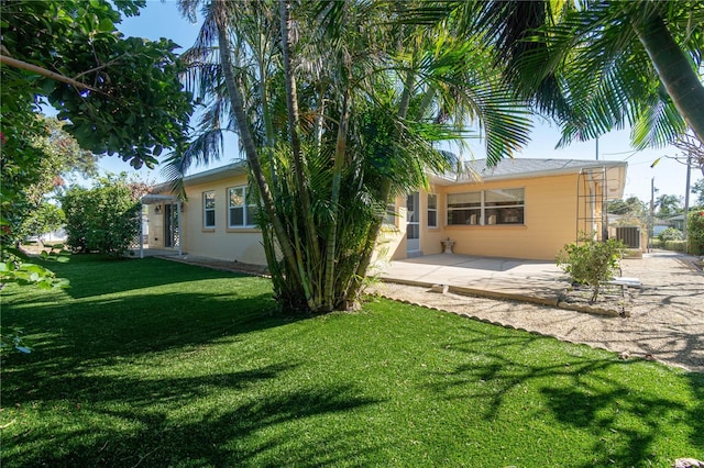 back of house with a yard, a patio, and central air condition unit