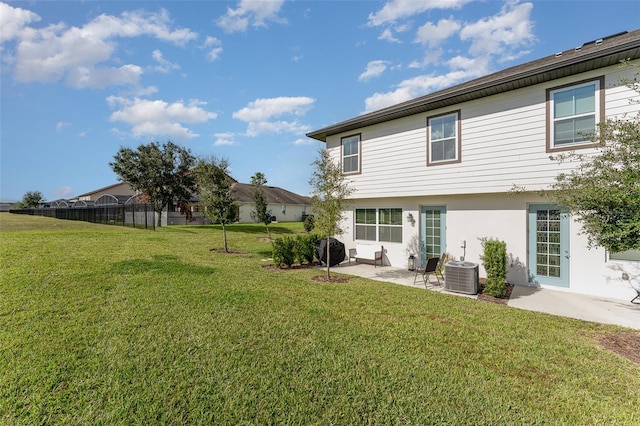 back of house featuring central AC, a patio area, and a lawn