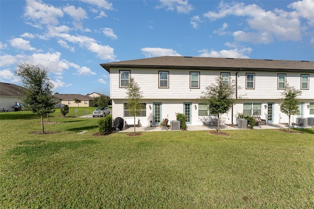 back of property with a lawn and central AC