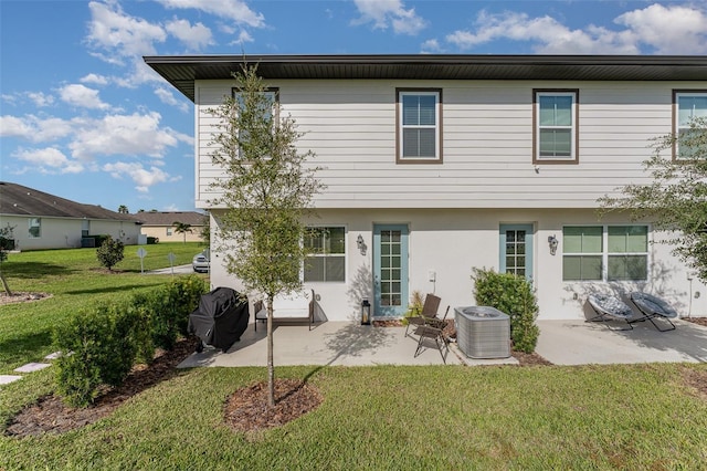 back of house with a yard, a patio, central AC unit, and stucco siding