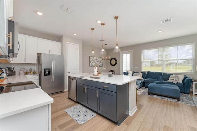 kitchen featuring visible vents, light wood-type flooring, light countertops, appliances with stainless steel finishes, and white cabinetry