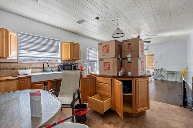 kitchen featuring hardwood / wood-style floors, decorative light fixtures, and wooden ceiling