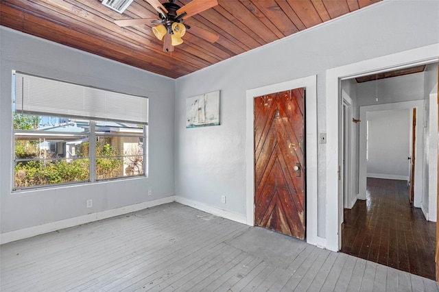 spare room featuring ceiling fan, a barn door, wood-type flooring, and wood ceiling