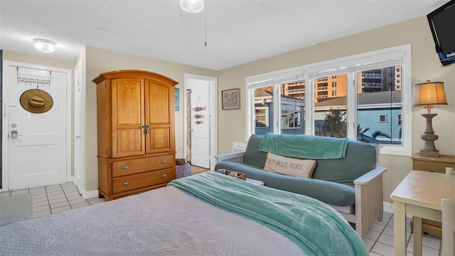 bedroom with a textured ceiling and light tile patterned flooring