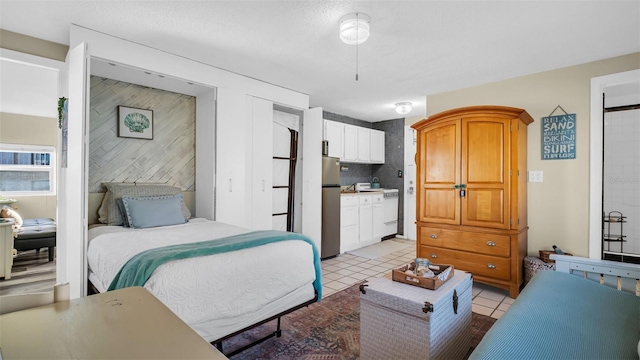 tiled bedroom with connected bathroom and stainless steel refrigerator