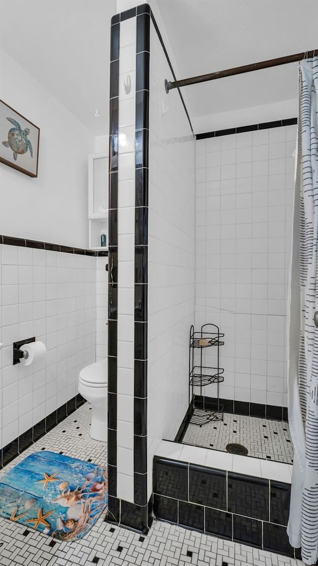 bathroom featuring toilet, tile patterned flooring, tile walls, and walk in shower