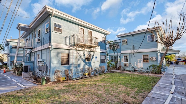 rear view of property with a yard and cooling unit