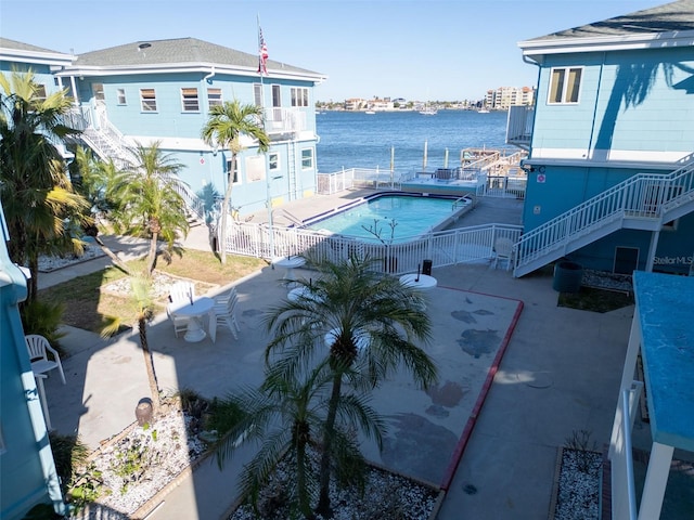 view of swimming pool featuring a patio area and a water view