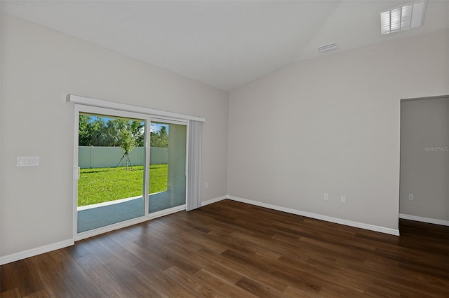 empty room featuring dark wood-type flooring and vaulted ceiling