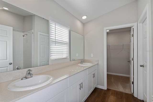 bathroom featuring vanity, wood-type flooring, lofted ceiling, and walk in shower