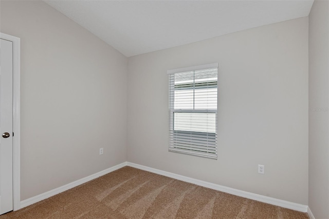 carpeted spare room with lofted ceiling