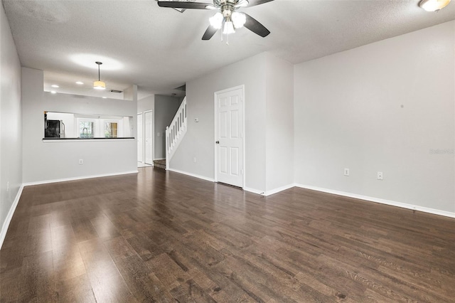 unfurnished living room with a textured ceiling, dark hardwood / wood-style flooring, and ceiling fan