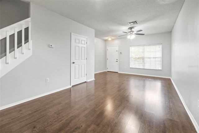 empty room featuring a textured ceiling, dark hardwood / wood-style floors, and ceiling fan