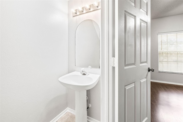 bathroom featuring wood-type flooring, a textured ceiling, and sink