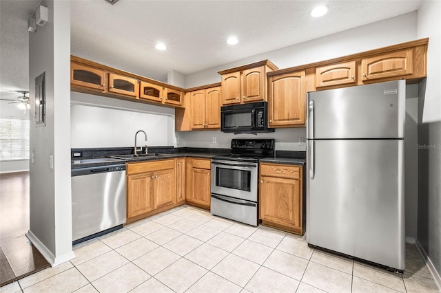 kitchen with ceiling fan, sink, a textured ceiling, light tile patterned floors, and appliances with stainless steel finishes