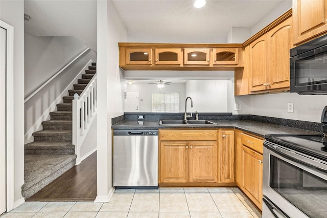 kitchen with appliances with stainless steel finishes, light tile patterned floors, ceiling fan, and sink