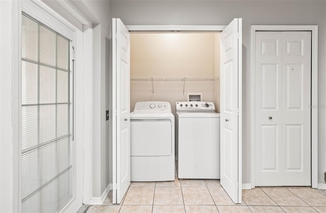 laundry room featuring washing machine and dryer and light tile patterned floors