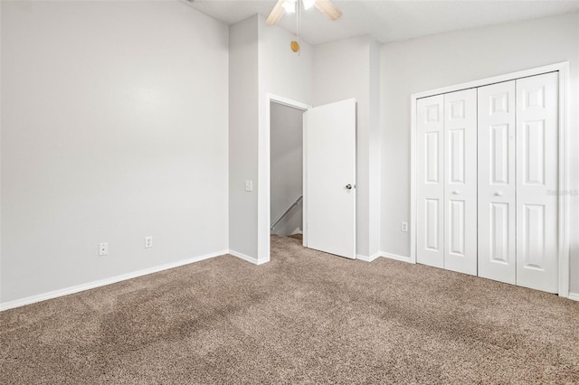 unfurnished bedroom with carpet floors, a closet, ceiling fan, and lofted ceiling