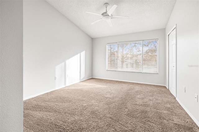 carpeted empty room with ceiling fan and a textured ceiling