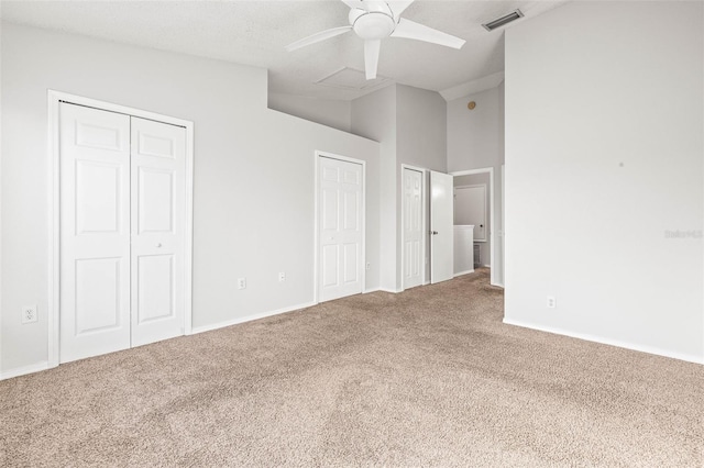 unfurnished bedroom featuring ceiling fan, carpet floors, and two closets