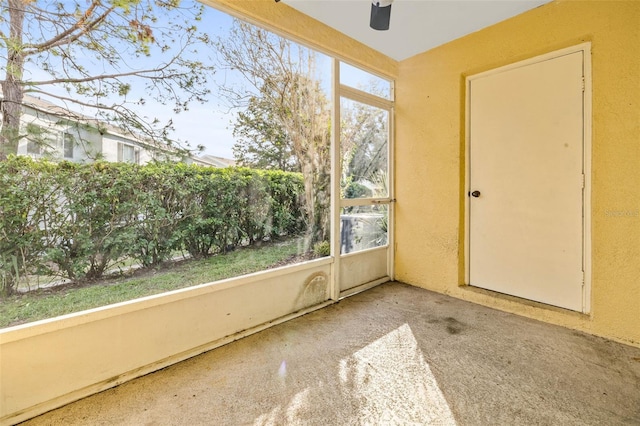 unfurnished sunroom featuring ceiling fan