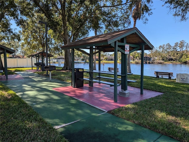 surrounding community featuring a water view and a lawn