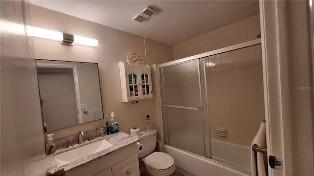 full bathroom with toilet, bath / shower combo with glass door, and vanity