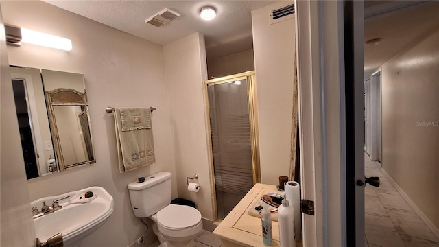 bathroom with sink, a shower with door, and toilet