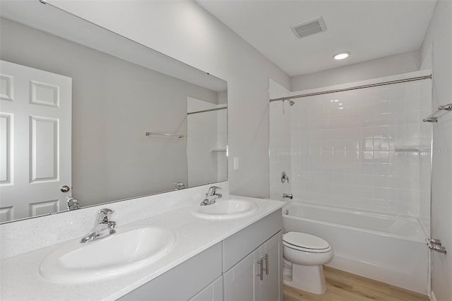 full bathroom featuring vanity, washtub / shower combination, wood-type flooring, and toilet