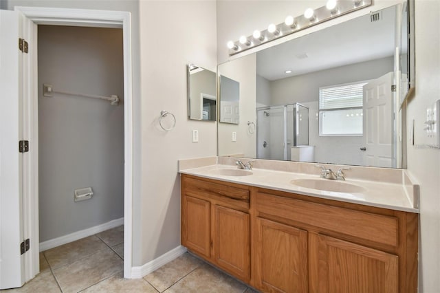 bathroom featuring tile patterned flooring, vanity, and a shower with door