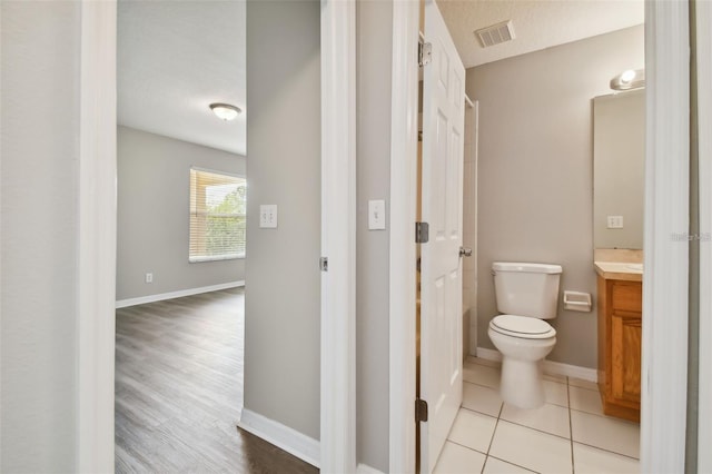 bathroom featuring hardwood / wood-style floors, vanity, toilet, and a textured ceiling