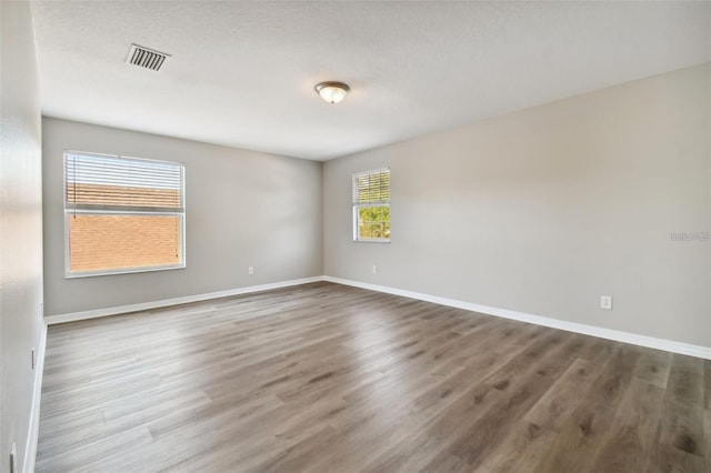 unfurnished room featuring a textured ceiling and dark wood-type flooring