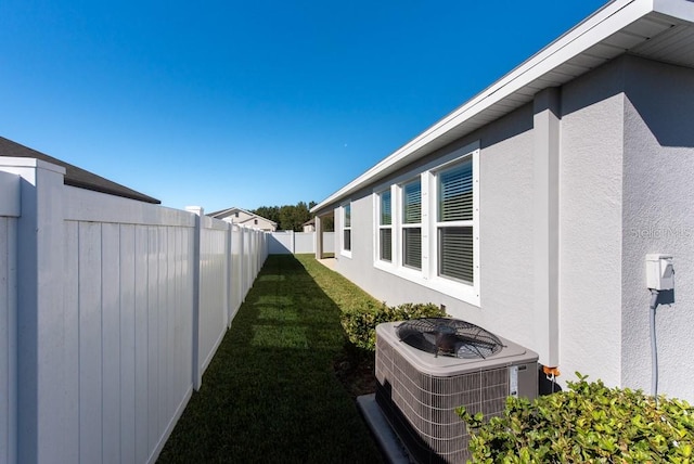 view of property exterior with central air condition unit and a lawn