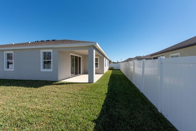 back of house featuring a lawn and a patio area